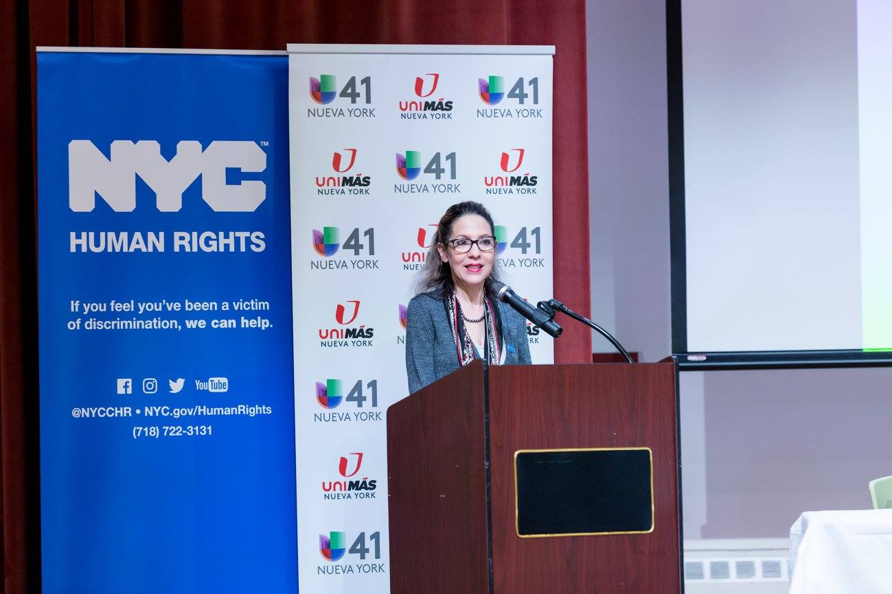 A woman standing behind a podium speaking at a workshop
