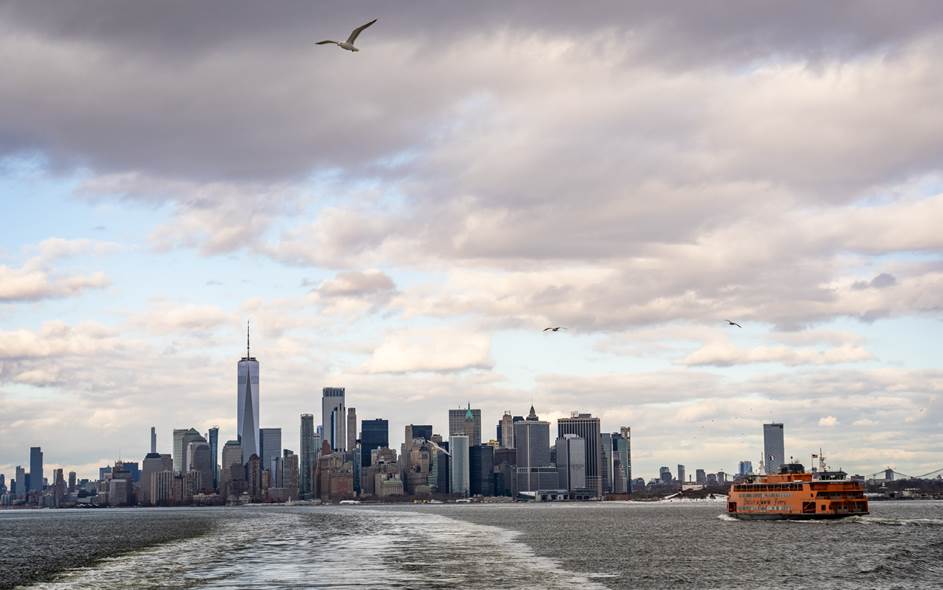 A boat on the water with a city skyline in the background.  Description generated by AI