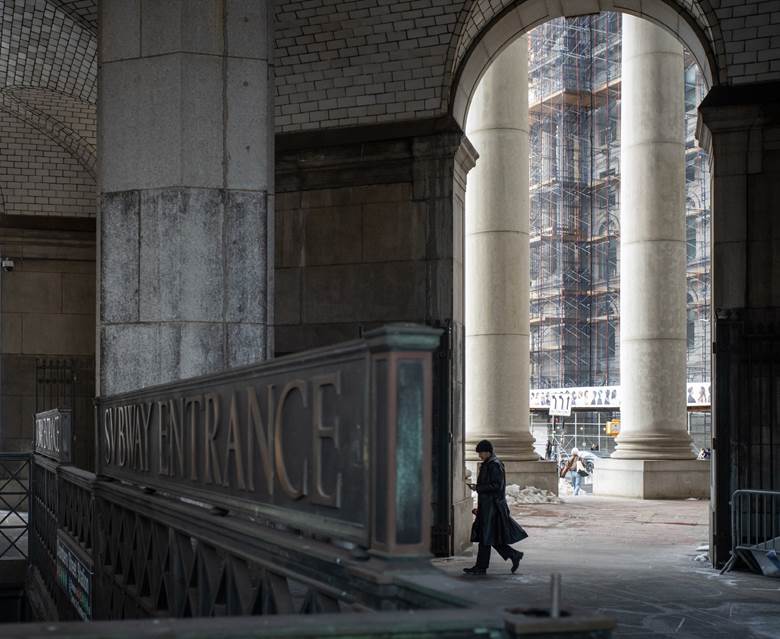 A man is walking in front of a building with a sign that says "convenience".  Description generated by AI