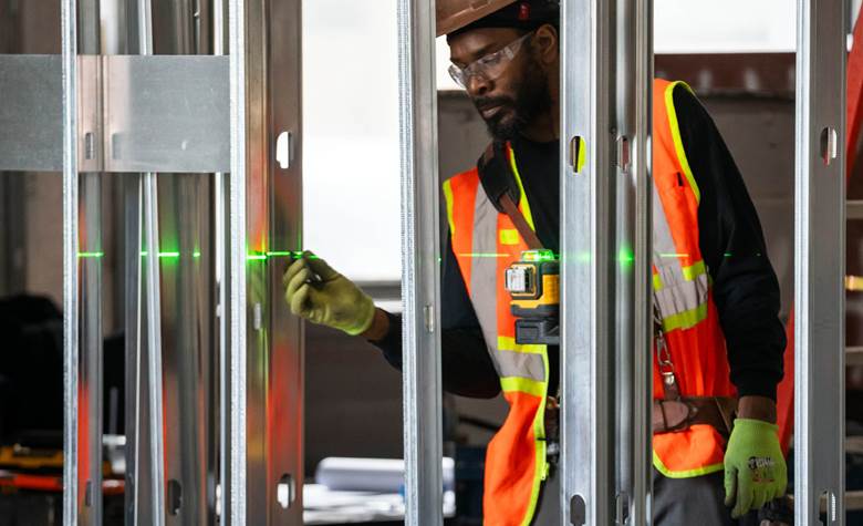 A man wearing a safety vest is working on a construction site.  Description generated by AI