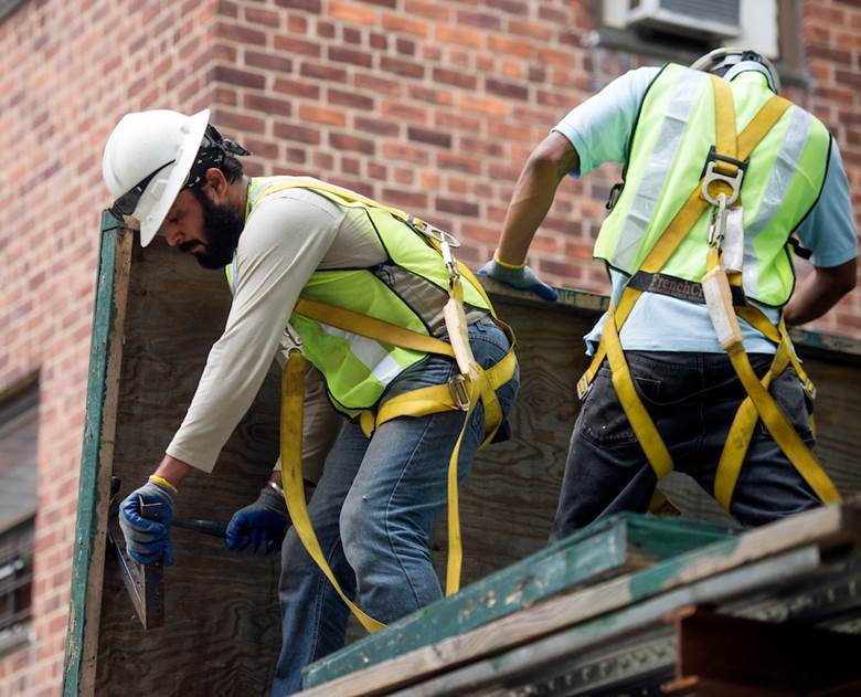 Two men working on a building.  Description generated by AI