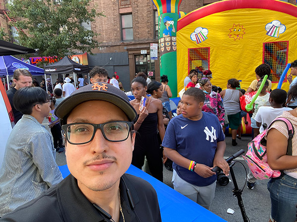 a man with glasses looking at the camera while a people by him behind