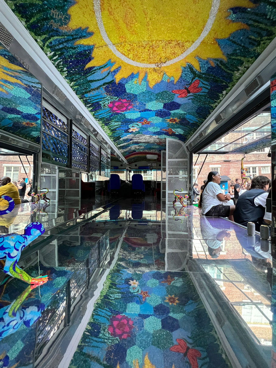 Insdie of a bus that is painted with drawing of the sun and variety colors