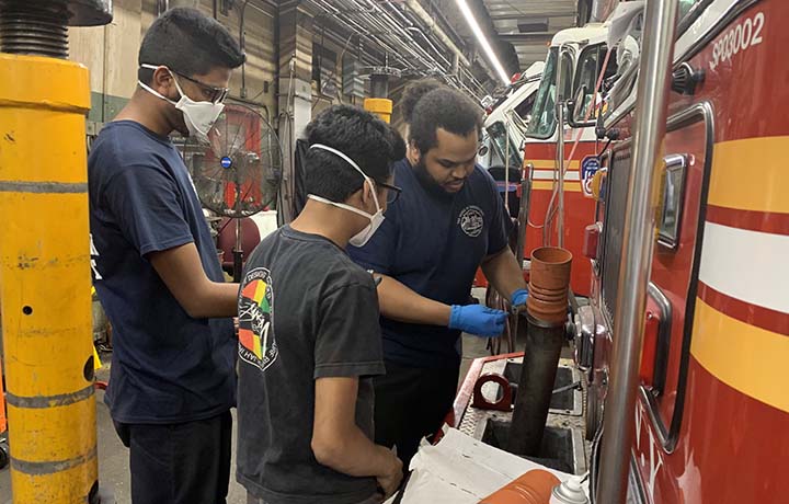 High School Automotive Internship Program Automotive interns assisting FDNY staff member.
