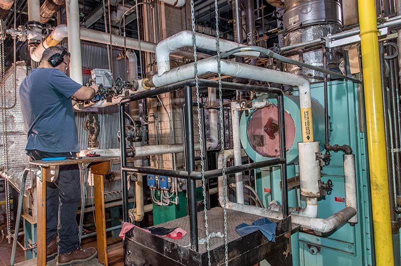 A city worker testing the belt drive system of a facility’s cooling system.