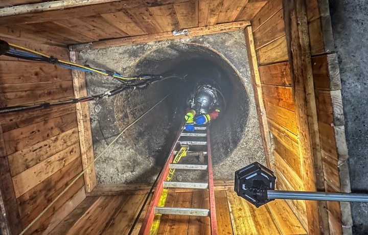 Worker entering interceptor sewer
