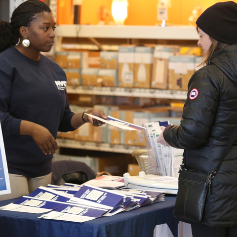 A DEP employee hands a pamphlet to a member of the public