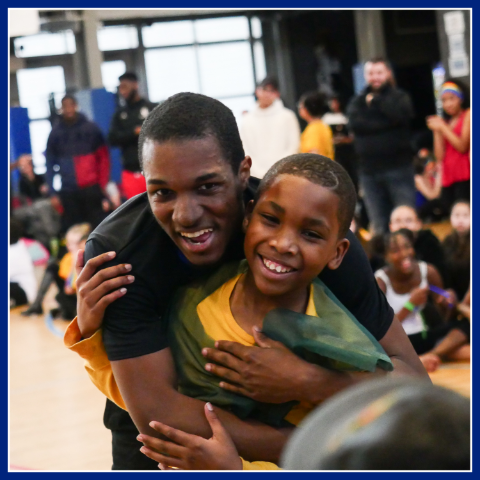 a young boy is embraced by father as they pose for a picture.  Healthy families programs.