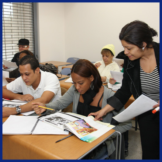 teacher showing book to adult student sitting in classroom