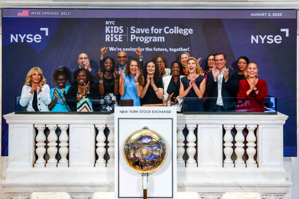 Pictured from left to right: Susan Lacher, Director, Koeppel Auto Group; Zhyla Landy and Nadia Landy, student and parent in the Save for College Program; Murray Abeles, Chief of Administration + Finance, NYC Kids RISE; Dionne Jaggon, Principal, P.S. 111; Bishop Mitchell G. Taylor, Co-Founder & CEO, Urban Upbound; Dana Zucker, Chief Executive Officer, Gray Foundation; Debra-Ellen Glickstein, Founding Executive Director, NYC Kids RISE; Ebony Young, Queens Deputy Borough President; Sideya Sherman, Commissioner, NYC Mayor's Office of Equity; Jade Grieve, Chief of Student Pathways, NYC Public Schools; Tara Dziedzic, Head of Listings - US Sectors, New York Stock Exchange; Vilda Vera Mayuga, Commissioner, NYC Department of Consumer and Worker Protection; Michael Gianaris, Senate Deputy Leader, New York State Senate; Roxanne Franklin Lorio, Chief of Staff, Greenwood Initiative, Bloomberg Philanthropies; and Lisa Hidalgo, Acting Superintendent, Community School District 30.  (Photo by NYSE, August 2023.)
