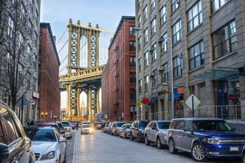 Photo of an entire street with the Manhattan Bridge in the background