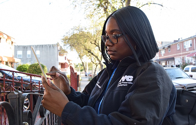 HPD inspector taking notes outdoors.