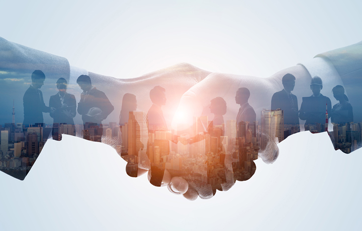 Image of two hands shaking with images of diverse business owners conversing against the NYC skyline