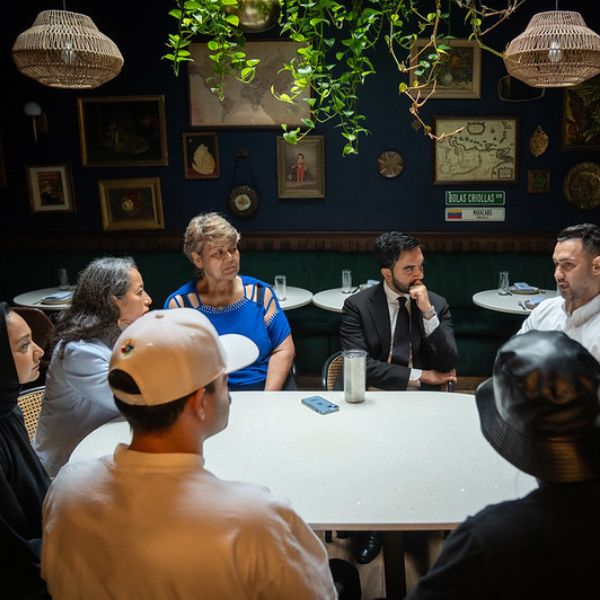 A group of people sit around a table at a restaurant during a meeting
