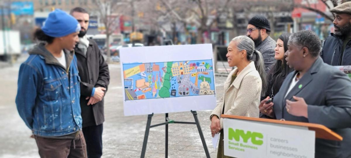 Local artist Daniel Bonilla presents First Deputy Mayor Maria Torres-Springer and SBS Commissioner Dynishal Gross a rendering of a mural that will be funded through a 2024 Public Realm Grant awarded to the Fordham Road BID