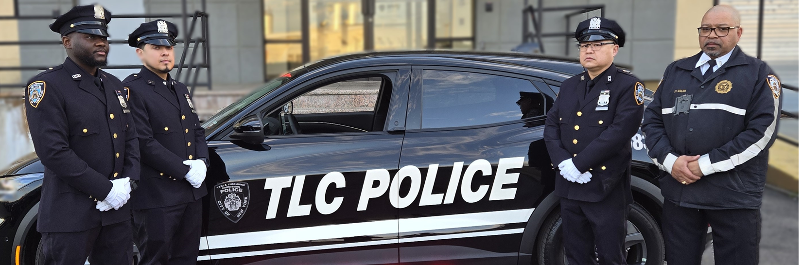 Black TLC Police Car with four TLC officers standing in front of the car. Black TLC Police Car with four TLC officers standing in front of the car