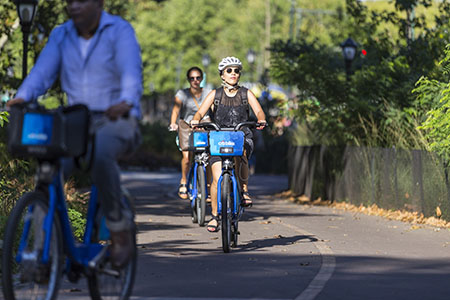 Bicyclists riding Citi Bike bikes along the Hudson River Greenway.