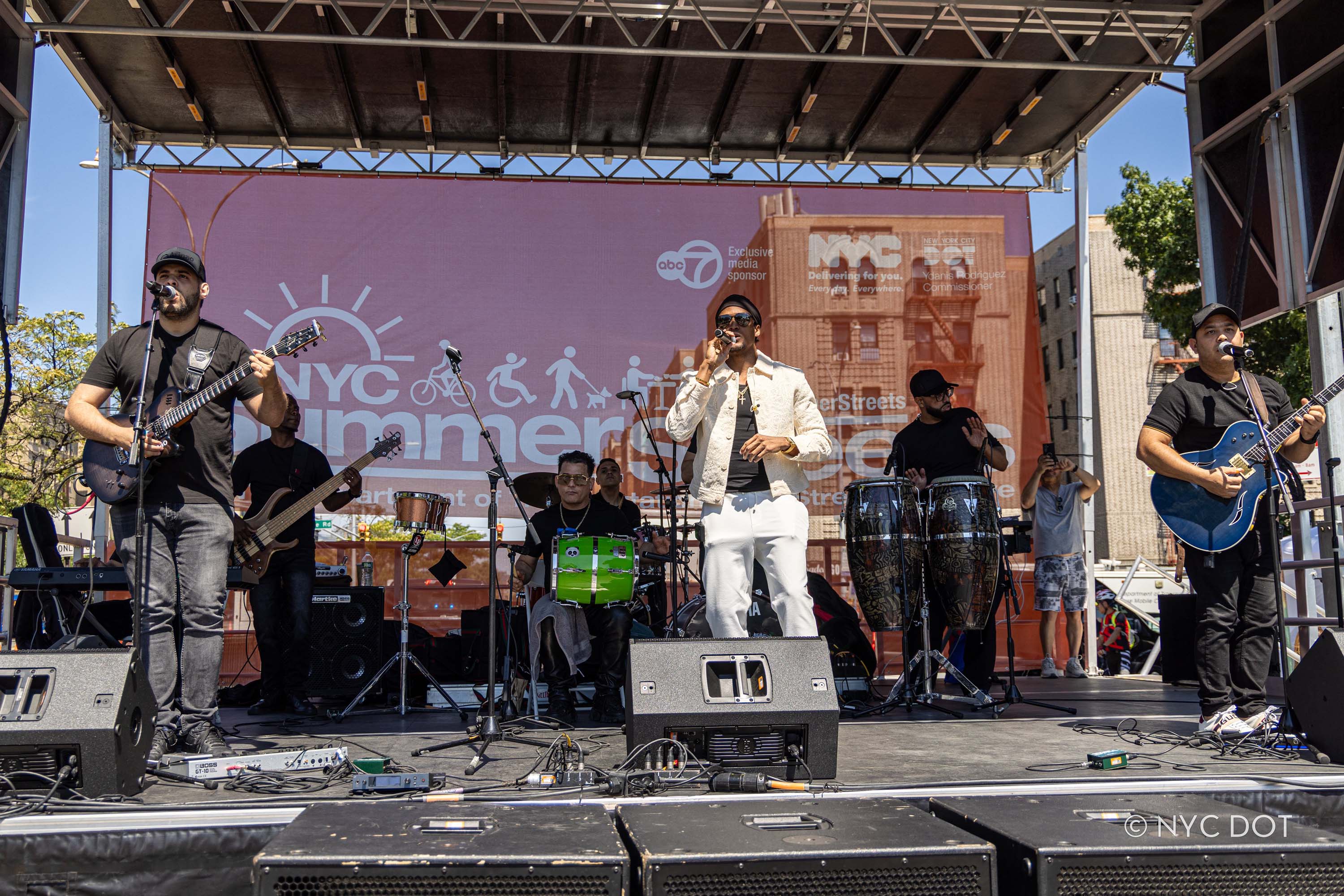 A group of musicians perform on a Summer Streets stage during a summertime event in NYC.