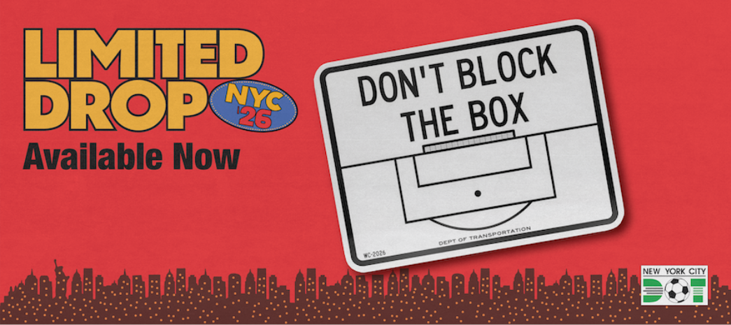 White and black rectangular sign reads Don't Block the Box and includes outlines of the penalty and goal boxes in front of a soccer goal. Limited drop by N Y C D O T.