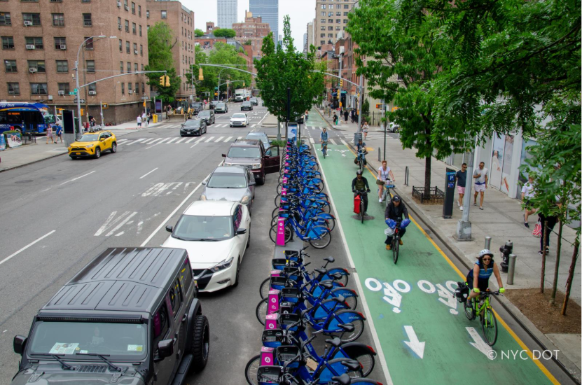 Cyclists travel along Ninth Avenue in a protected bike lane.